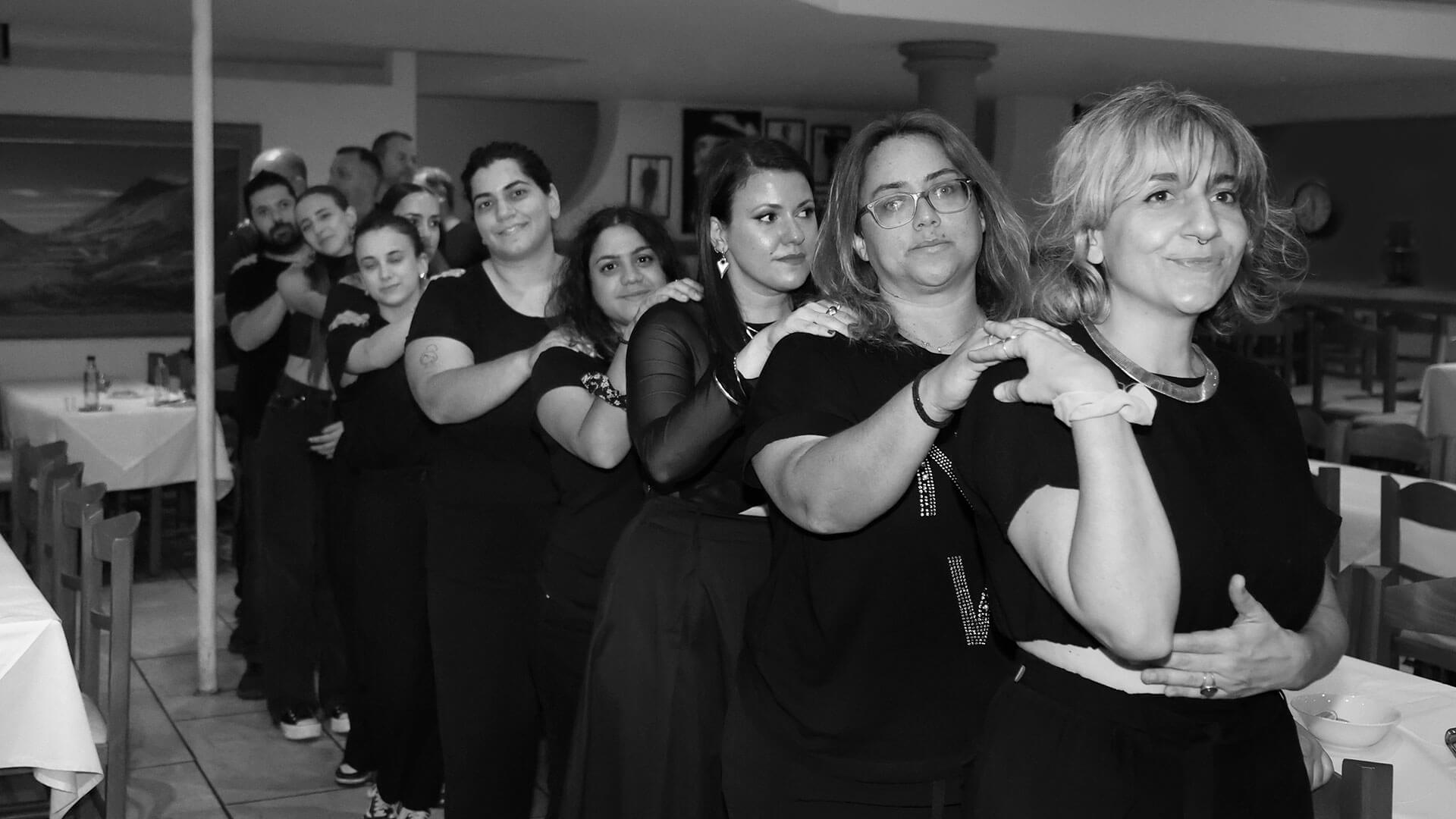 Οι εθελοντές με το δεξί χέρι του ενός να ακουμπάει τον δεξί ώμο του μπροστινού στη σειρά.